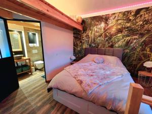 Saint-André-le-GazSuite Love et Evasion的一间卧室配有一张带热带壁纸的床
