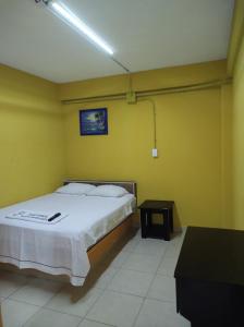 ComalcalcoNovHotel的卧室配有一张黄色墙壁上的床