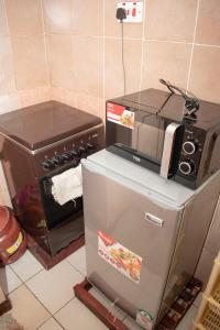 BungomaAriBri Apartment, Bungoma Town.的厨房配有炉灶、冰箱和微波炉
