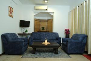 卡兰古特2 BHK beach goan villa with pool calangute的客厅配有2把蓝色椅子和咖啡桌