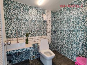 巴色Via Hostel Pakse的浴室拥有蓝色和白色的瓷砖墙壁,设有卫生间