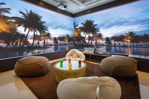 千叶ホテルバリアンリゾート千葉中央的客房享有大海和棕榈树的景致。