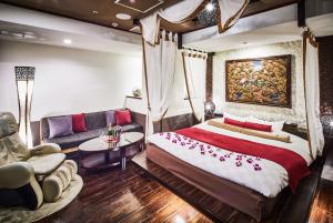 千叶ホテルバリアンリゾート千葉中央的一间卧室配有一张大床和一张沙发