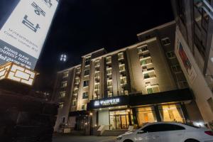 全州市Pungnam Tourist Hotel的夜间停在大楼前的汽车