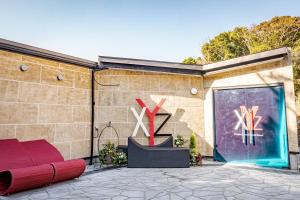 白滨XYZ私人Spa中心及海滨度假酒店 的砖砌的建筑,设有红色的沙发和玻璃门