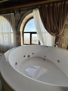 格雷梅基岩窑洞酒店的窗户客房内的大浴缸