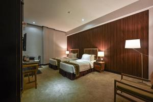 马六甲1825格乐瑞酒店的酒店客房配有两张床和一张书桌