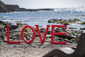 白滨XYZ私人Spa中心及海滨度假酒店 的岩石海滩上的红色标志,读到爱情