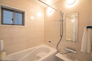 大阪-旅タイム・岸里夏也 - 岸里玉出駅 大型車駐車場あり的设有带浴缸和淋浴的浴室。