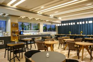 阿萨夫哈罗芬班古里昂机场萨杜特酒店 - 阿特拉斯精品酒店的一间带桌椅的餐厅和一间酒吧