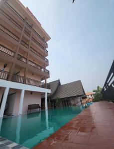 万荣Vangvieng Sisavang Mountain View Hotel的一座建筑前面设有游泳池