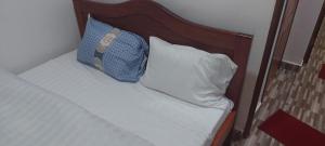 基加利RUbuto ABNB的一张带木制床头板的床和两个枕头