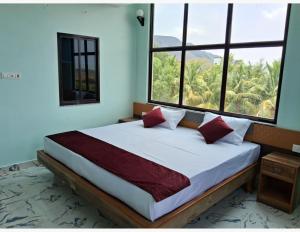 王舍城Hotel Gridhakuta International的一间卧室设有一张大床和两个窗户