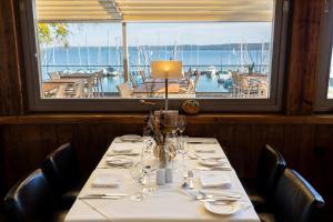 贝尔恩里德Marina Hotel am Starnberger See的享有船景的餐厅餐桌