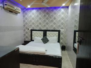 新德里Hotel lodge kalkaji的紫色灯室里一间卧室,配有一张床