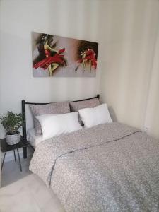 沃洛斯Στουντιο Βολος Ν Ιωνια的卧室配有一张床,墙上挂有绘画作品