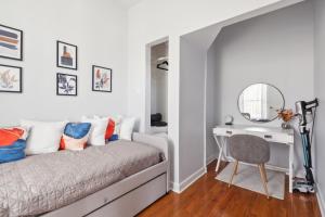 芝加哥Comfortable Condo in the Heart of Bronzeville condo的一间卧室配有一张带书桌和镜子的床