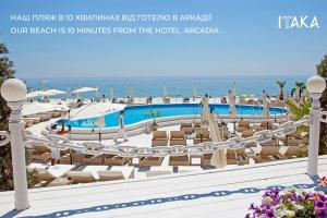 敖德萨守护神酒店的一个带游泳池和椅子的度假胜地和大海