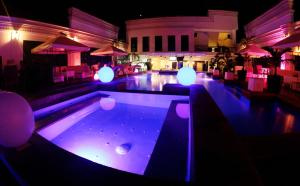 安吉利斯阁楼居家酒店的餐厅内带紫色灯的游泳池