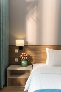 河内首都花园酒店的一间卧室设有两张床和一张花瓶桌子。