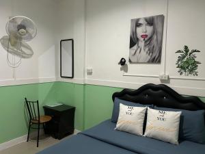 沙美岛Labella samet guesthouse的一间卧室配有一张带照片的床和风扇
