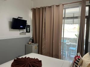 沙美岛Labella samet guesthouse的客房设有床、电视和窗户。