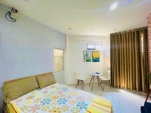 岘港TINA HOUSE Apartment的一间卧室配有一张床和一张桌子
