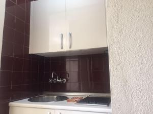 多列毛利诺斯Apartamento en el centro de Torremolinos的厨房配有水槽和白色橱柜