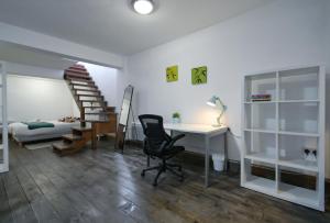 伦敦Stoke Newington Studio by DC London Rooms的客房设有书桌、椅子和床。