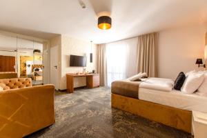 尼彻兹Pokoje z wyżywieniem i krytym basenem w Amber Park Spa的酒店客房,设有两张床和一张沙发
