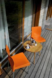 托波尔希卡Apartma Bazilika的门廊上配有两把橙色椅子和一张咖啡桌