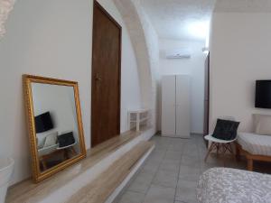 朱尔迪尼亚诺Gli Archi Country Home的一间设有镜子、一张床和一张沙发的房间