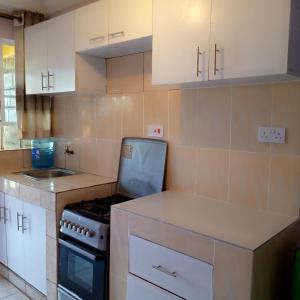 ThikaVerona Airbnb的厨房配有白色橱柜和炉灶烤箱。