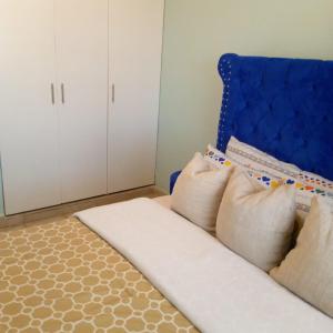 ThikaVerona Airbnb的一间设有蓝色沙发和三个枕头的客房