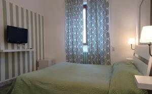朱尔迪尼亚诺Gli Archi Country Home的一间卧室设有一张绿色的床和一个窗户。