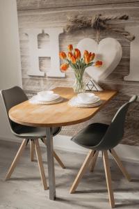 施韦因福特Stilvolles Apartment的一张带两把椅子的木桌和花瓶