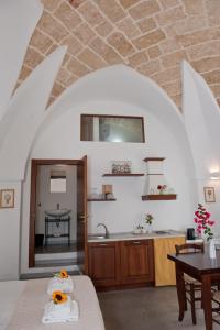 乌真托La Corte Della Luce的厨房以及带桌子和水槽的客厅。