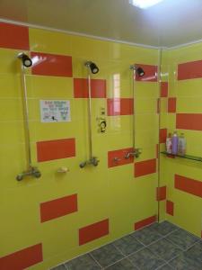 庆州庆州友谊旅馆的浴室墙壁上装饰有黄色和橙色条纹