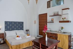 乌真托La Corte Della Luce的一间卧室配有一张床铺和一张桌子,还设有一间厨房