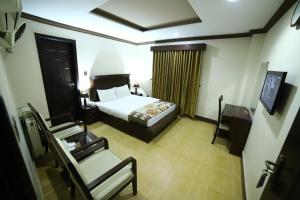 伊斯兰堡Midtwon Hotel Islamabad的配有一张床和一把椅子的酒店客房