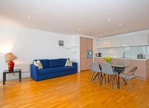伦敦伦敦市中心舒适公寓的客厅配有蓝色的沙发和桌子
