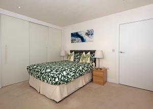 伦敦伦敦市中心舒适公寓的一间卧室配有一张带黑白色床罩的床。