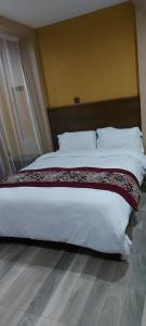 马查科斯Lysak Haven Park hotel的卧室配有一张带白色床单和枕头的大床。