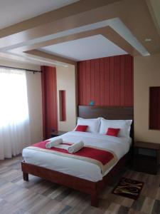 马查科斯Lysak Haven Park hotel的一间卧室设有一张带红色墙壁的大床