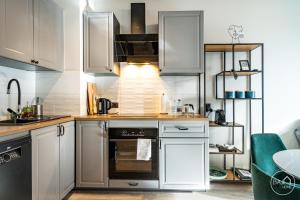 索斯诺维茨Green Harmony Apartment的厨房配有白色橱柜和烤箱。