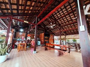 Tân PhúHOMESTAY HƯƠNG RỪNG的一间设有木桌和长凳的餐厅
