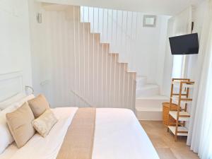 德尼亚Casa Portet的一间白色的卧室,配有床和楼梯