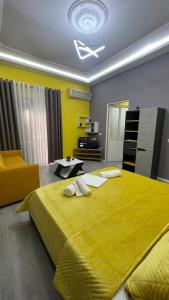培拉特Algen Room's的一间卧室配有一张黄色的大床和一张沙发