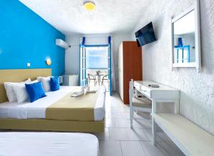 卡尔帕索斯Bluu Bahari Hotel的酒店客房设有两张床、一张书桌和一个窗户。