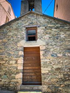 BigornoNuits magiques au village entre mer et montagnes的砖砌的建筑,有门和窗户